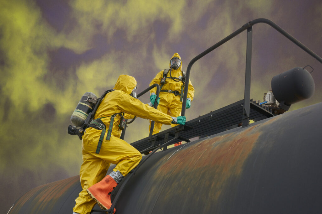 Workers in Lakeland ChemMax liquid splash protective suit working on a train, demonstrating chemical protection for liquid hazard environments.
