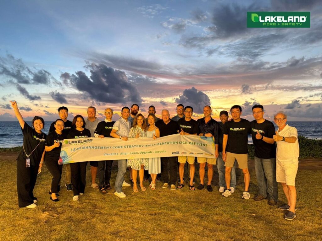Team at sunset lean management kickoff event on beach.