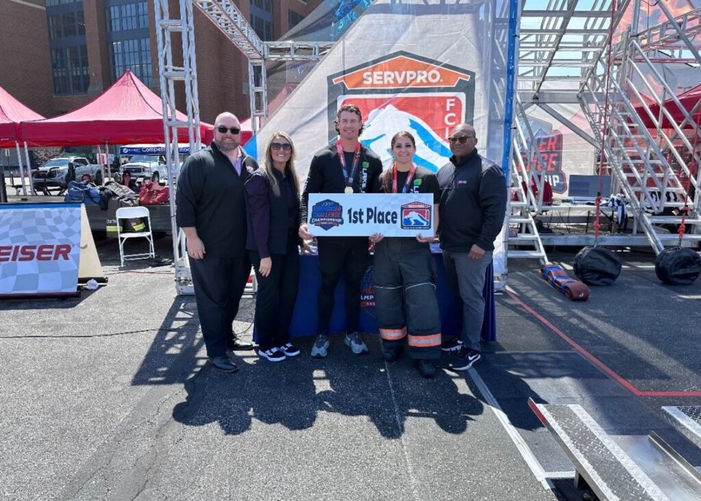 Group celebrates first-place victory at outdoor event.